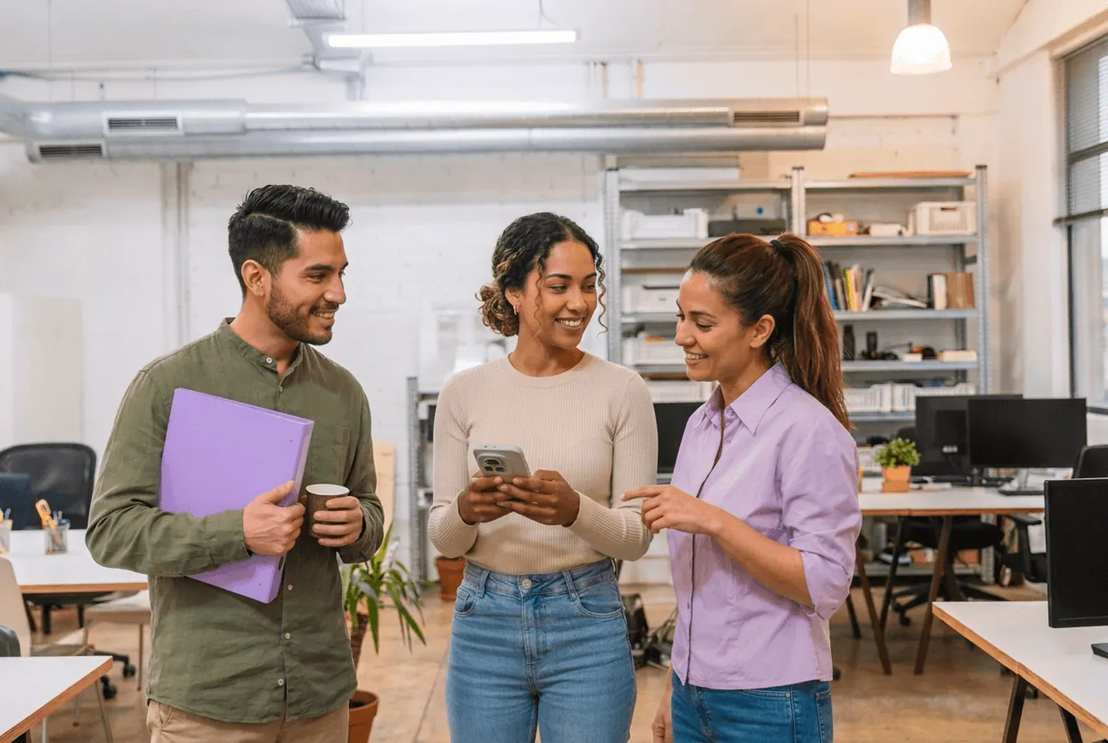 Tres personas consultan un aviso de la empresa en un teléfono.